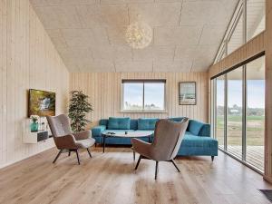 Vejbyにある18 person holiday home in Vejbyのリビングルーム(青いソファ、椅子2脚付)