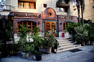 ein Hotel mit Pflanzen vor einem Gebäude in der Unterkunft Pearl Hotel, Maadi in Kairo