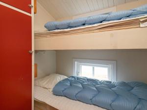 ブラーバンドにある4 person holiday home in Bl vandのベッドルーム1室(二段ベッド2台、窓付)が備わります。