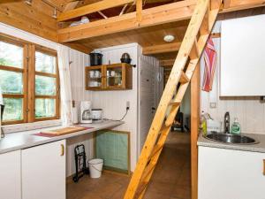 a kitchen with a staircase in a tiny house at 7 person holiday home in Kolind in Kolind