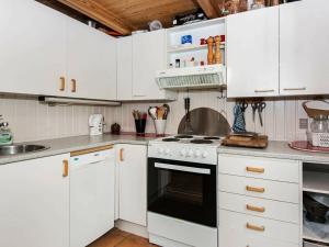 a kitchen with white cabinets and a stove top oven at 7 person holiday home in Kolind in Kolind
