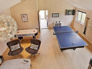 Vejbyにある16 person holiday home in Vejbyの卓球台と椅子が備わる卓球ルーム