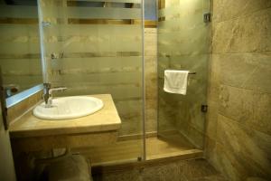 a bathroom with a sink and a glass shower at Pearl Hotel, Maadi in Cairo