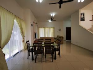 a dining room and living room with a table and chairs at Venn Homestay, Balik Pulau in Balik Pulau