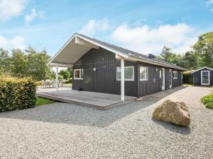 een huis met een houten veranda en een rots bij Holiday home Juelsminde XLVIII in Juelsminde