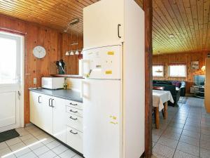 cocina con nevera blanca y mesa en Four-Bedroom Holiday home in Harboøre 12, en Harboør