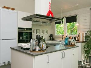 a kitchen with white cabinets and a black counter top at Holiday home Rønde IX in Rønde