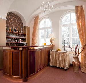 eine Bar mit einem Tisch in einem Zimmer mit Fenstern in der Unterkunft Hotel Metropol in Franzensbad