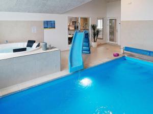カッペルンにある18 person holiday home in Hasselbergの家屋内の青い滑り台付きスイミングプール