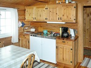 eine Küche mit Holzschränken, einer Spüle und einem Tisch in der Unterkunft 4 person holiday home in Surna in Glerem