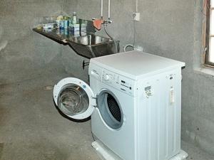 eine Waschmaschine und ein Waschbecken in einem Zimmer in der Unterkunft 4 person holiday home in Surna in Glerem