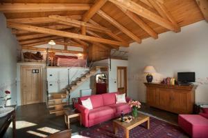 a living room with a pink couch and a staircase at Villa Tiboldi in Canale