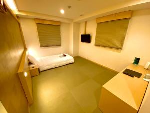 سرير أو أسرّة في غرفة في Namba Ebisu Hotel