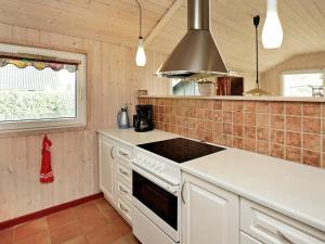 a kitchen with white cabinets and a stove top oven at 6 person holiday home in Hemmet in Hemmet