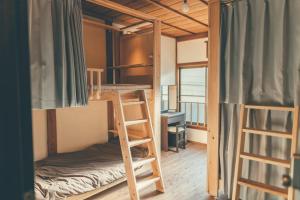 a room with two bunk beds and a desk at ゲストハウス 宰嘉庵 かなで GuestHouse Saikaan KANADE in Maizuru