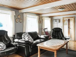 een woonkamer met zwarte lederen meubels en een tafel bij 5 person holiday home in R m in Toftum