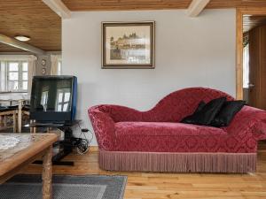 un sofá rojo en la sala de estar con TV en 5 person holiday home in R m en Toftum