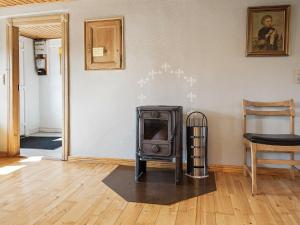 a stove in a living room with a wooden floor at 5 person holiday home in R m in Toftum