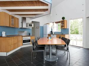 a kitchen with a wooden table and chairs at 10 person holiday home in Ebeltoft in Ebeltoft
