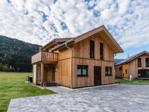a timber house with a deck on a field at Murau Chalet 8 in Laßrchberg