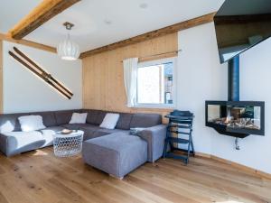 a living room with a couch and a tv at Murau Chalet 8 in Laßrchberg