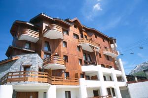 a building with balconies on the side of it at Madame Vacances Lodges des Alpages in La Plagne