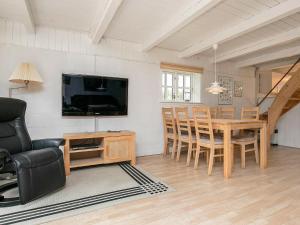 a living room with a dining room table and a television at Holiday Home Grævlingevej II in Mosevrå