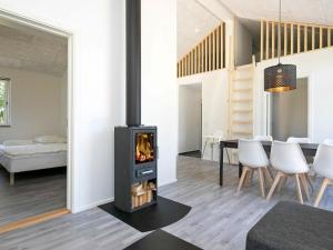 a living room with a fireplace and a dining room with a table at 8 person holiday home in L s in Læsø