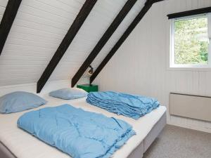 a bedroom with two beds with blue sheets and a window at 6 person holiday home in Knebel-By Traum in Skødshoved Strand