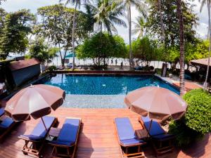 una piscina con sedie e ombrelloni accanto ad essa di Chaweng Garden Beach Resort - SHA Plus a Chaweng Beach