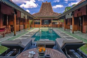 a pool in a house with a table and chairs at Villa Berawa in Canggu