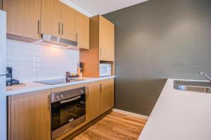 a kitchen with a stove a sink and a microwave at Wallaroo Marina Apartments in Wallaroo