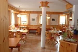 a restaurant with tables and chairs and a pole in a room at Seppl Stoba in Schruns