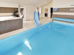 a large blue swimming pool with a bath tub at 20 person holiday home in Vejby in Vejby