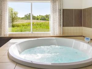 uma grande banheira numa casa de banho com uma janela em 20 person holiday home in Vejby em Vejby