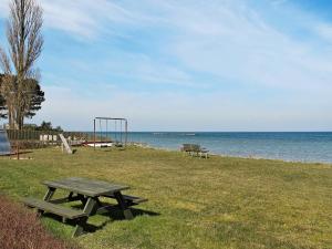 a picnic table in the grass next to a playground at 6 person holiday home in Str by in Strøby