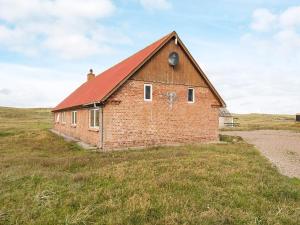 an old brick barn in the middle of a field at 7 person holiday home in Harbo re in Harboør