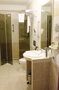 a bathroom with a sink and a shower and a toilet at Hotel Dorottya in Kaposvár