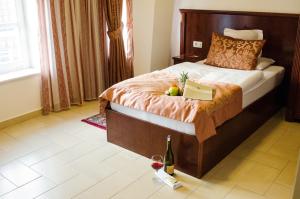 a hotel room with a bed with a bottle of wine and a book at Hotel Dorottya in Kaposvár