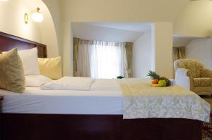a bedroom with a bed with a bowl of fruit on it at Hotel Dorottya in Kaposvár