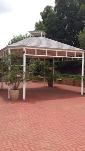 un pabellón con techo sobre un suelo de ladrillo en The Shakespeare Inn, en Vanderbijlpark