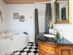 a bathroom with a tub and a sink at 7 person holiday home in Hemmet in Hemmet