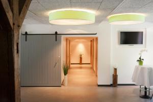 a hallway with a sliding door and a television at Hotel zur Kloster-Mühle in Groß Meckelsen