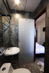 a bathroom with a sink and a toilet and a bed at Hotel Wualai by CMStay in Chiang Mai