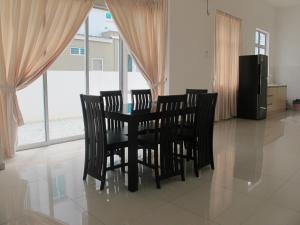 uma sala de jantar com uma mesa e quatro cadeiras em Properties Homestay, Balik Pulau em Balik Pulau