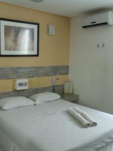 サルバドールにあるホテル エレガンスの白いベッド(白いタオル2枚付)