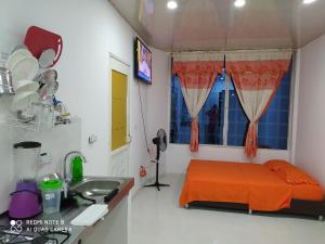 ein Krankenhauszimmer mit einem Bett und einem Waschbecken in der Unterkunft Apartaestudios El Descanso in Cali