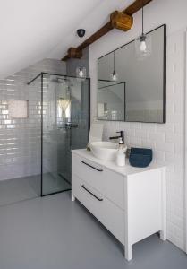 a white bathroom with a sink and a shower at Hygge Hut in Vama