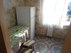 una cucina con frigorifero, tavolo e finestra di Однокомнатная квартира рядом с метро Оболонь a Kiev