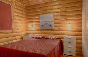 1 dormitorio con 1 cama en una habitación de madera en Lekotti Vacation Club, en Savonranta